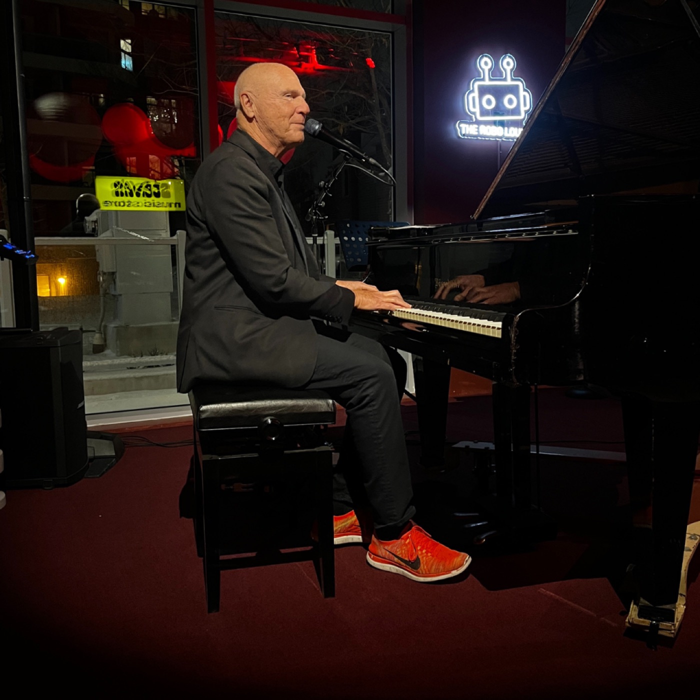 A pianist performing beneath The Robo Lounge sign.