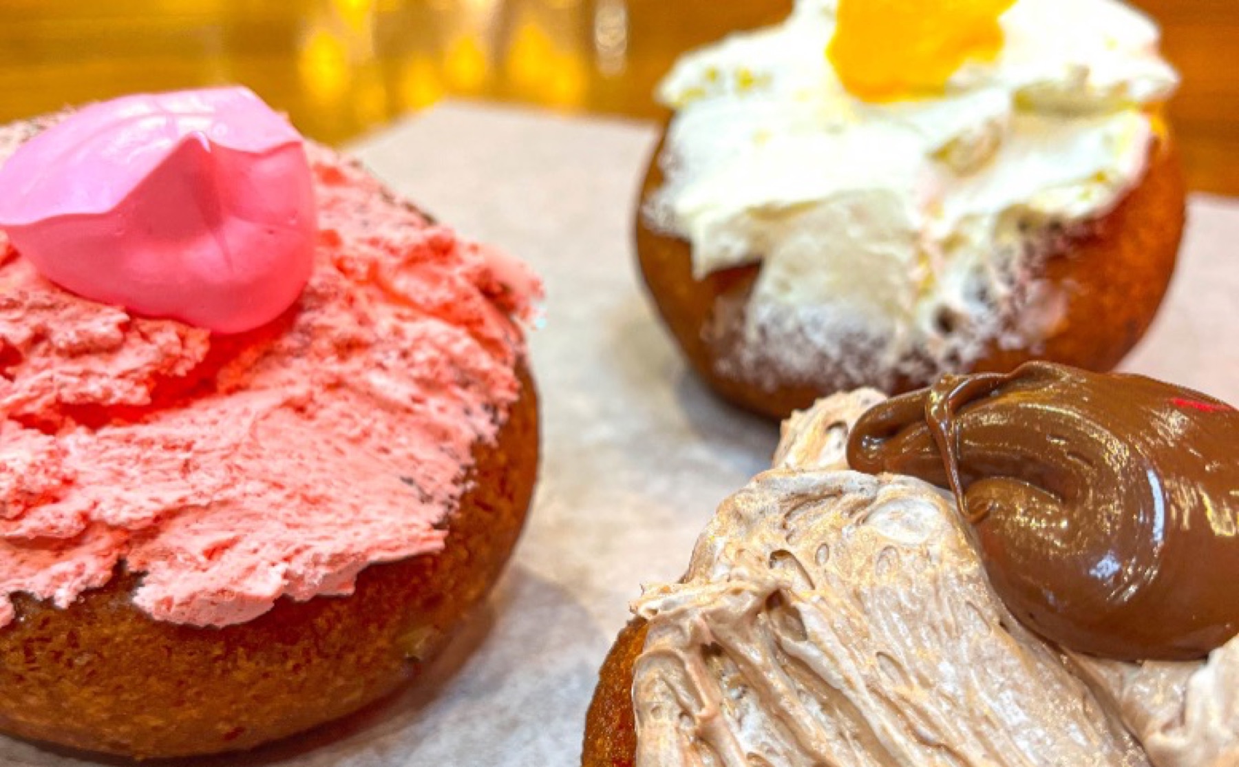 Three iced and cream-topped baked treats.