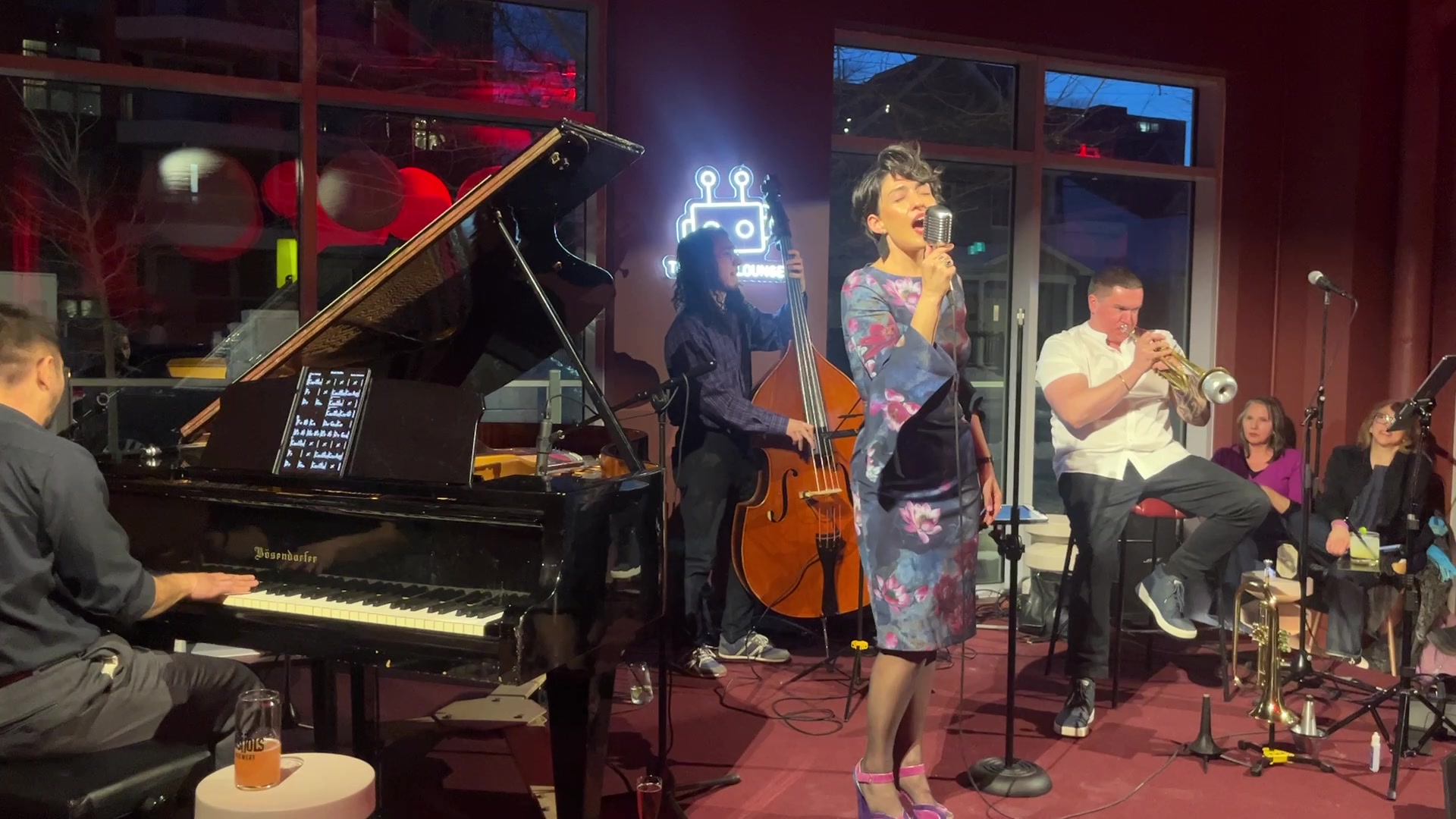 Musicians performing together beside the grand piano at The Robo Lounge.